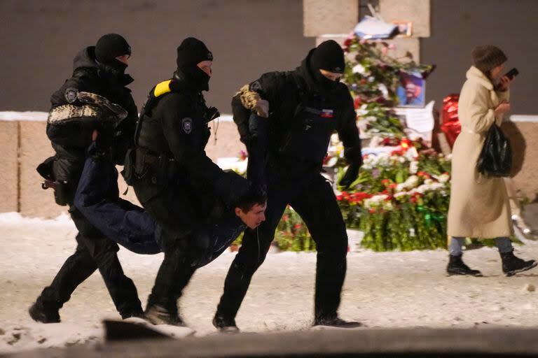 Agentes de policía detienen a un hombre que depositaba flores para Alexei Navalny en un monumento a las víctimas de la represión política, en San Petersburgo, Rusia, el 16 de febrero de 2024. 