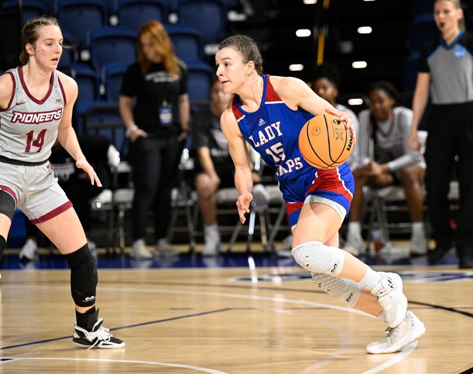 Lubbock Christian University guard Shaylee Stovall (15) drives by Texas Woman's guard Sadie Moyer (14) during a first-round game of the Division II NCAA Tournament.