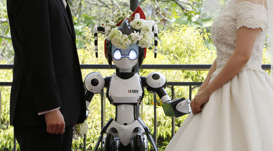 A humanoid robot named “I-Fairy” acts as a witness at the wedding ceremony between Tomohiro Shibata (L) and Satoko Inoue in Tokyo May 16, 2010. Reuters/Yuriko Nakao