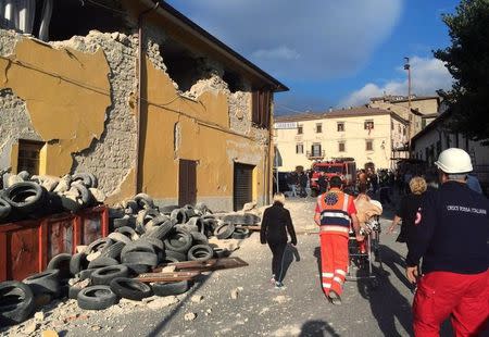 Rescuers and people walk along a road following an earthquake in Accumuli di Rieti, central Italy, August 24, 2016. REUTERS/Steve Scherer