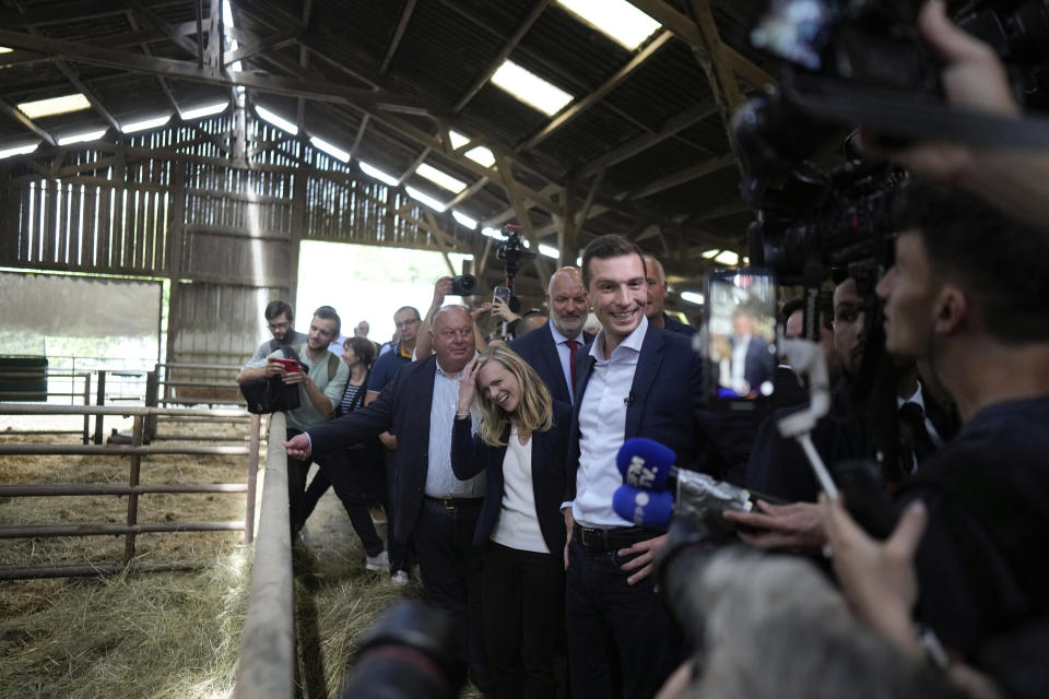 Jordan Bardella far-right National Rally leader for the upcoming election, right, speaks to the media as he visits a farm in Chuelles, 137 kms (85 miles) south of Paris, Friday, June 14, 2024. The election is to take place in two rounds on June 30 and July 7. (AP Photo/Thibault Camus)