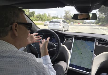 Reuters journalist Paul Ingrassia sits in the drivers seat of a Tesla S-Type in Autopilot mode in San Francisco, California, U.S., April 7, 2016. REUTERS/Alexandria Sage