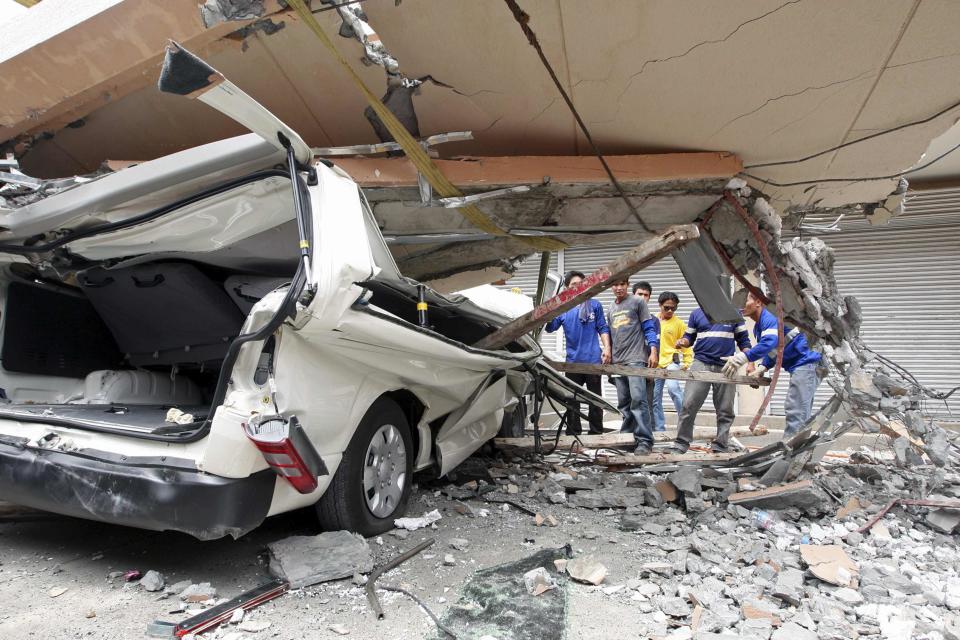 Residents inspect a car after a concrete block fell on it during an earthquake in Cebu city, central Philippines October 15, 2013. At least six people were killed when buildings collapsed on islands popular with tourists in the central Philippines on Tuesday, radio reports said, after an earthquake measuring 7.2 hit the region. (REUTERS)