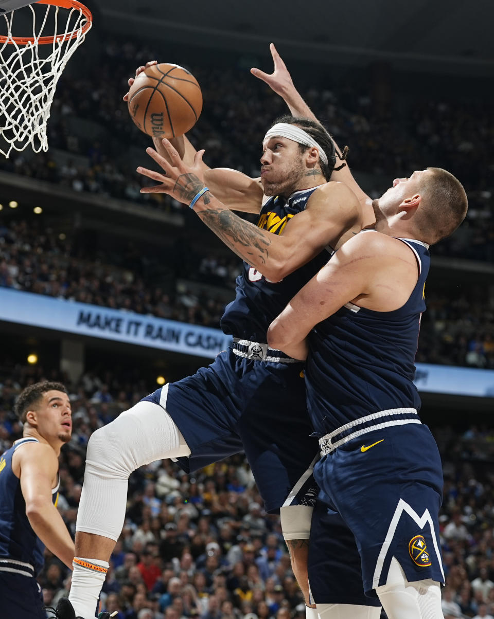 Denver Nuggets forward Aaron Gordon, center, pulls in a rebound in front of center Nikola Jokic in the second half of Game 5 of an NBA basketball first-round playoff series against the Los Angeles Lakers Monday, April 29, 2024, in Denver. (AP Photo/David Zalubowski)