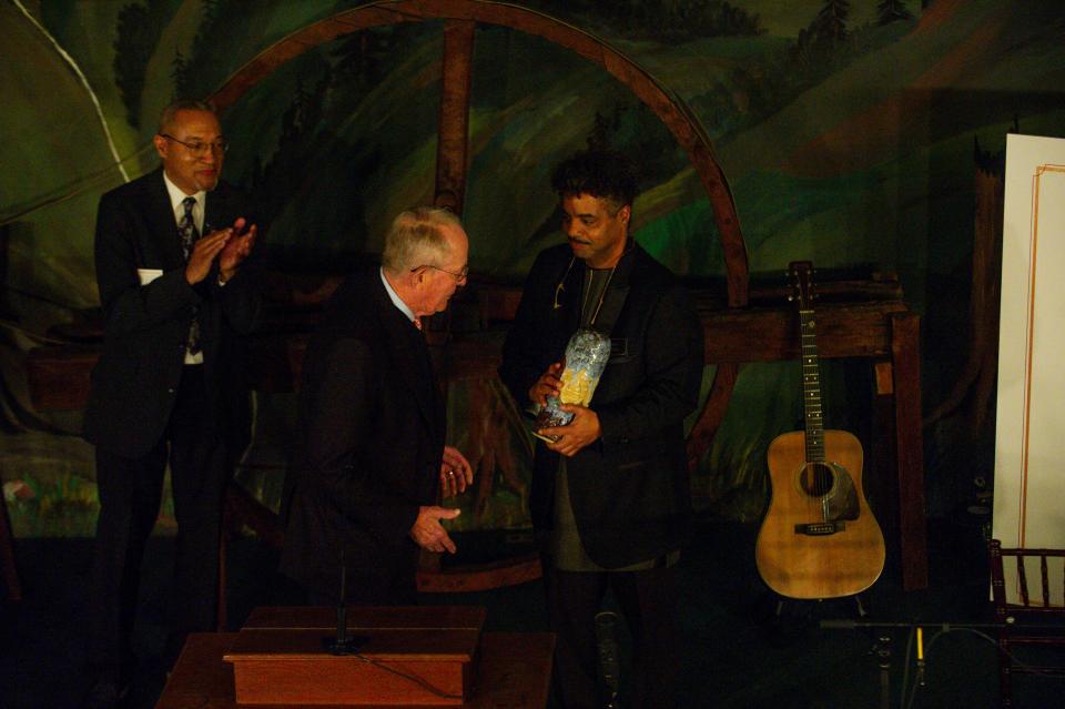 Former U.S. Sen. Lamar Alexander hands the award for "Heroes of Southern Appalachia" to Alex Haley's grandson, Bill Haley during a celebration of the life of Alex Haley at the Museum of Appalachia on Friday, March 1, 2024. On the other side of Alexander is Alex Haley's nephew Chris Haley.