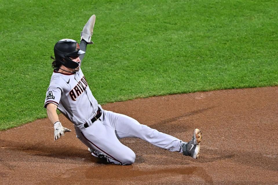 Corbin Carroll slides into third base in the first inning of Game 7.