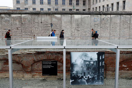 Visitors walk beside remains of the Berlin Wall at the Topography of Terror museum located at the site of the former Nazi Gestapo and SS headquarters, as Germany marks the 80th anniversary of Kristallnacht, also known as Night of Broken Glass in Berlin, Germany, November 9, 2018. REUTERS/Fabrizio Bensch