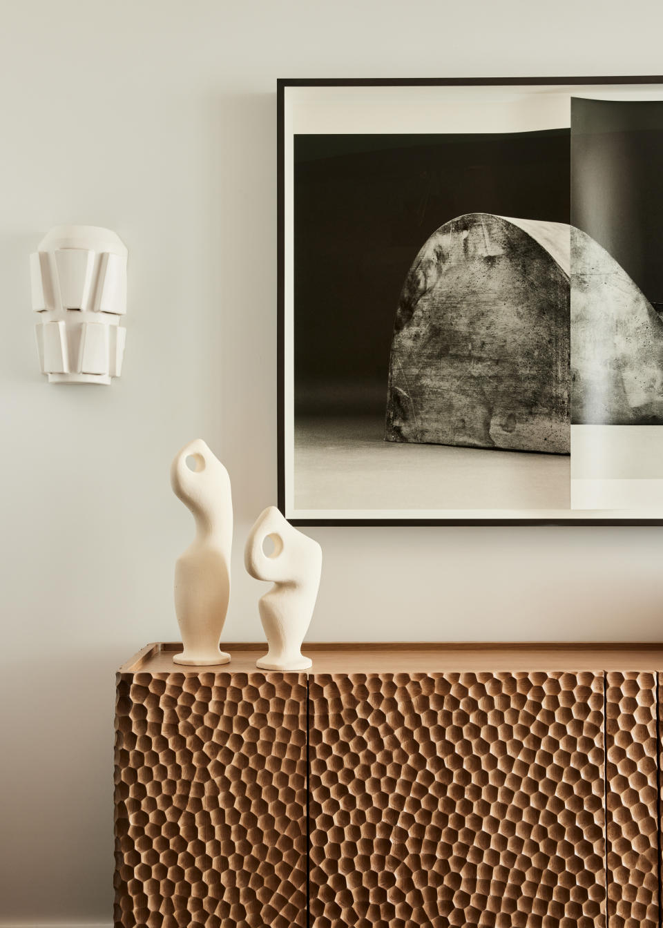 A wooden console kept against a cream wall