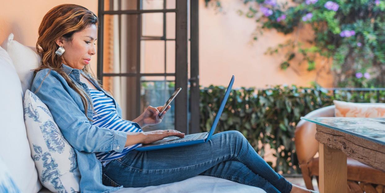 woman using laptop and cell phone at home