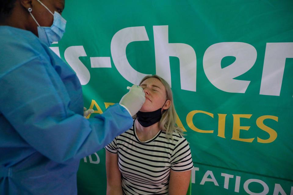 A healthcare worker conducts a polymerase chain reaction (PCR) Covid-19 test  on a traveller at OR Tambo International Airport in Johannesburg on 27 November 2021 (AFP via Getty Images)