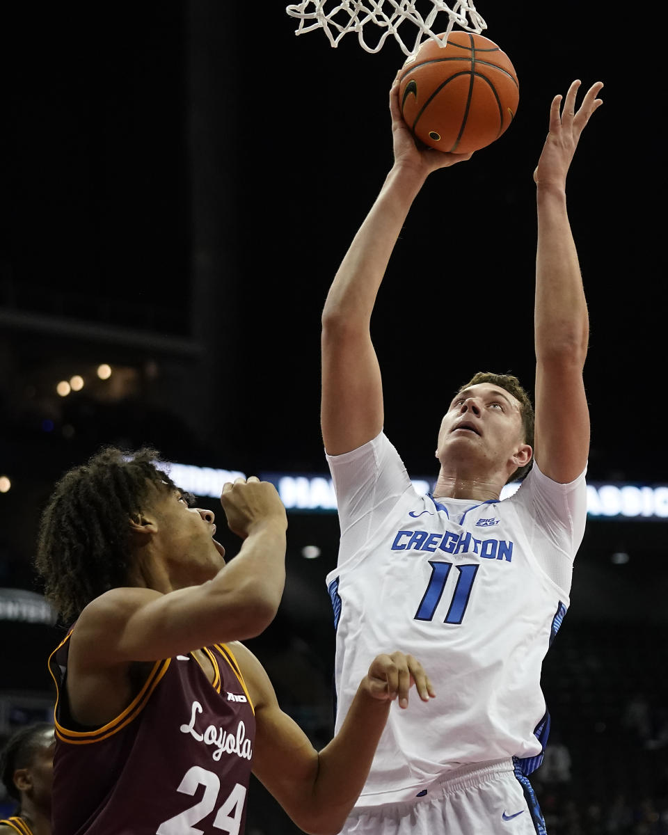 Creighton center Ryan Kalkbrenner (11) shoots over Loyola Chicago center Miles Rubin (24) during the first half of an NCAA college basketball game Wednesday, Nov. 22, 2023, in Kansas City, Mo. (AP Photo/Charlie Riedel)