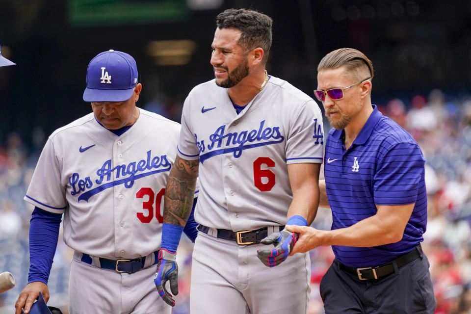 Los Angeles Dodgers manager Dave Roberts (30) walks off the field with David Peralta (6) after Peralta is hit by a pitch during the second inning of a baseball game against the Washington Nationals at Nationals Park, Sunday, Sept. 10, 2023, in Washington. (AP Photo/Andrew Harnik)