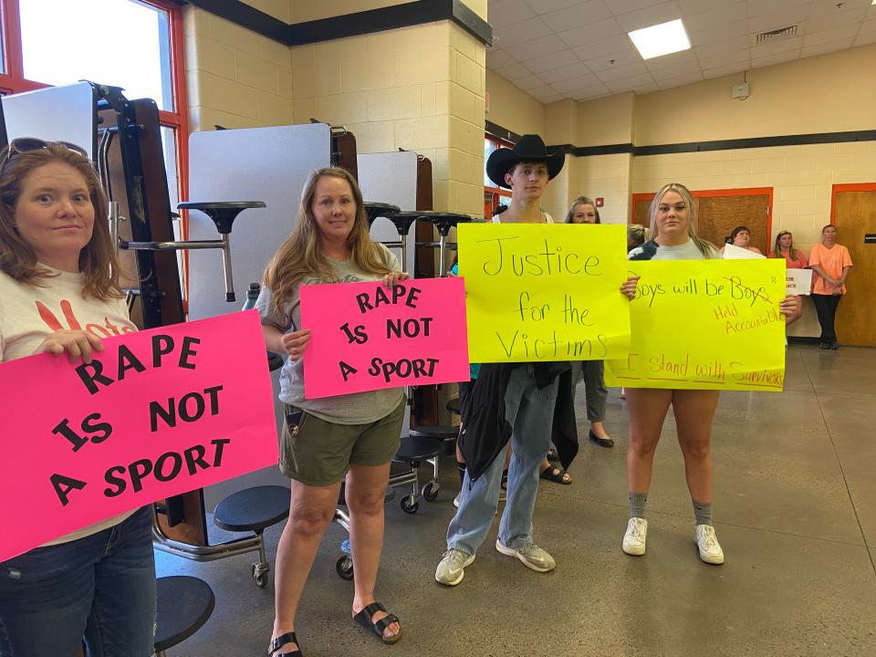 Lamar school district community members bring signs to protest at the board meeting on Monday, July 11 following the Title IX investigator's decision to suspend perpetrators of sexual violence for 10 days when school resumes in August.