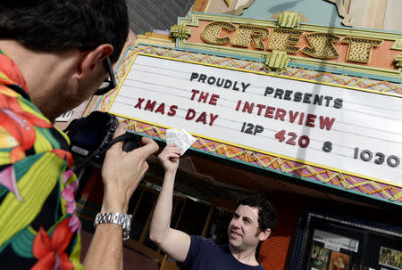 Tickets for the film "The Interview" is seen held up by theater manager Donald Melancon for the media at Crest Theater in Los Angeles, California December 24, 2014. REUTERS/Kevork Djansezian
