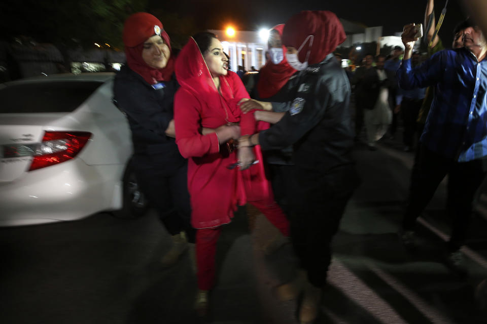 Police officers detain a supporter of Pakistan's Prime Minister Imran Khan outside the National Assembly after no-confidence vote, in Islamabad, Pakistan, Sunday, April 10, 2022. Pakistan's political opposition ousted the country's embattled prime minister in a no confidence vote on Saturday, which they won after several of Imran Khan's allies and a key coalition party deserted him. (AP Photo/Anjum Naveed)