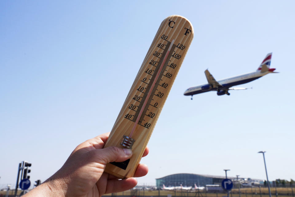 Someone holds a thermometer outside that reads over 100 degrees Fahrenheit