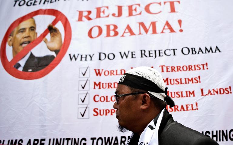 A Malaysian Muslim activist walks past a banner during a protest against US President Barack Obama's upcoming visit to Malaysia, outside the US Embassy in Kuala Lumpur on April 18, 2014