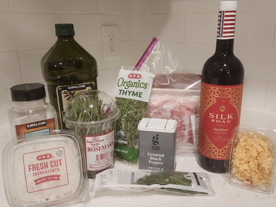 Ingredients for steak including meat, thyme, olive oil, and other herbs