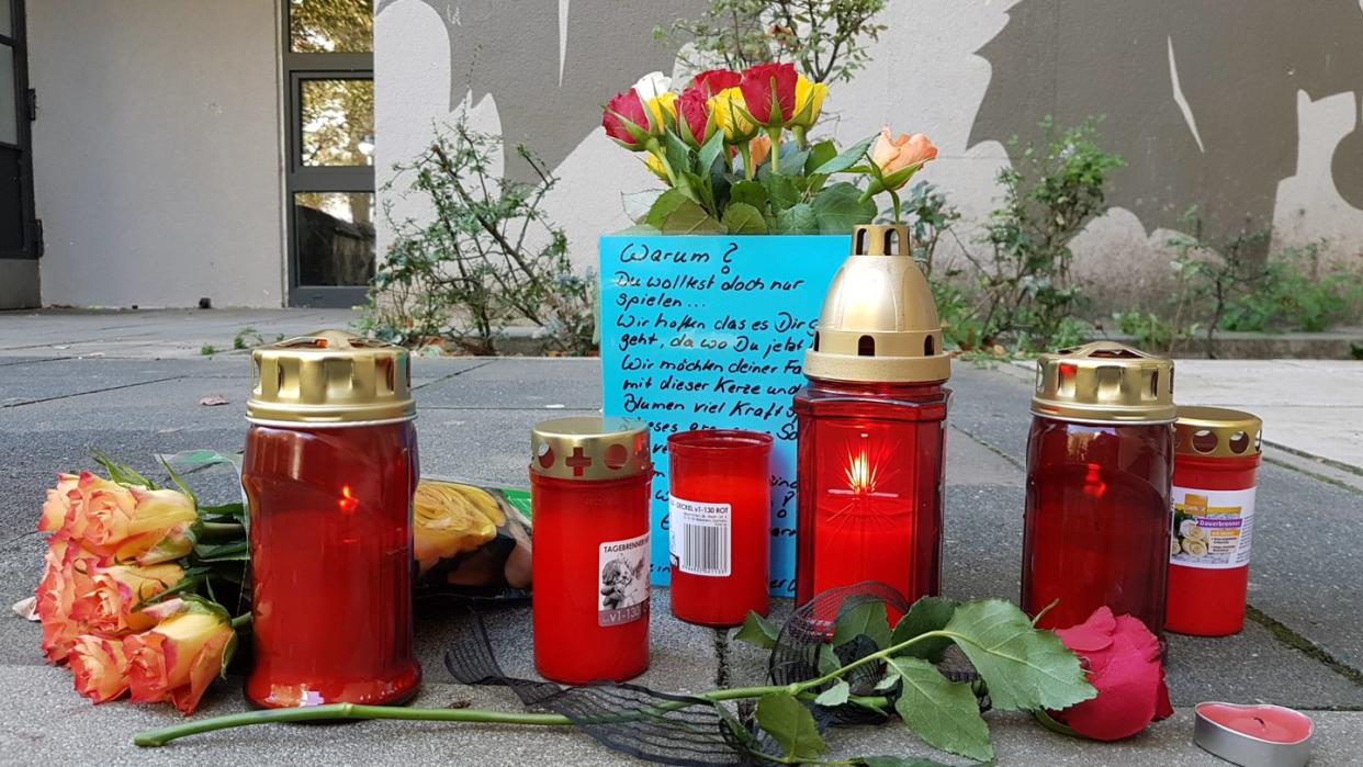 Im Märkischen Viertel in Berlin erinnern Kerzen und Blumen an den getöteten Achtjähriger. Er war von einem aus einem Hochhaus stürzenden Baumstumpf erschlagen worden. Foto: Julian Stähle