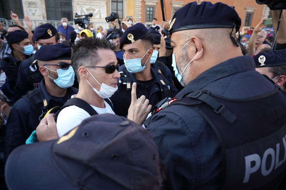 A man is taken away by police during a protest against the government restriction measures to curb the spread of COVID-19, in Rome, Saturday, Oct. 10, 2020. (AP Photo/Andrew Medichini)