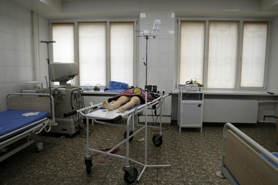 The lifeless body of a girl lies on a medical cart in a bare hospital room.