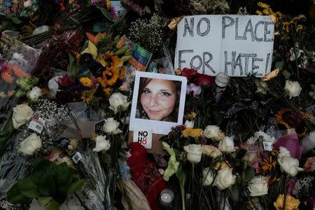 A photograph of Charlottesville victim Heather Heyer is seen amongst flowers left at the scene of the car attack on a group of counter-protesters that took her life during the "Unite the Right" rally as people continue to react to the weekend violence in Charlottesville, Virginia, U.S. on August 14, 2017. REUTERS/Justin Ide/Files