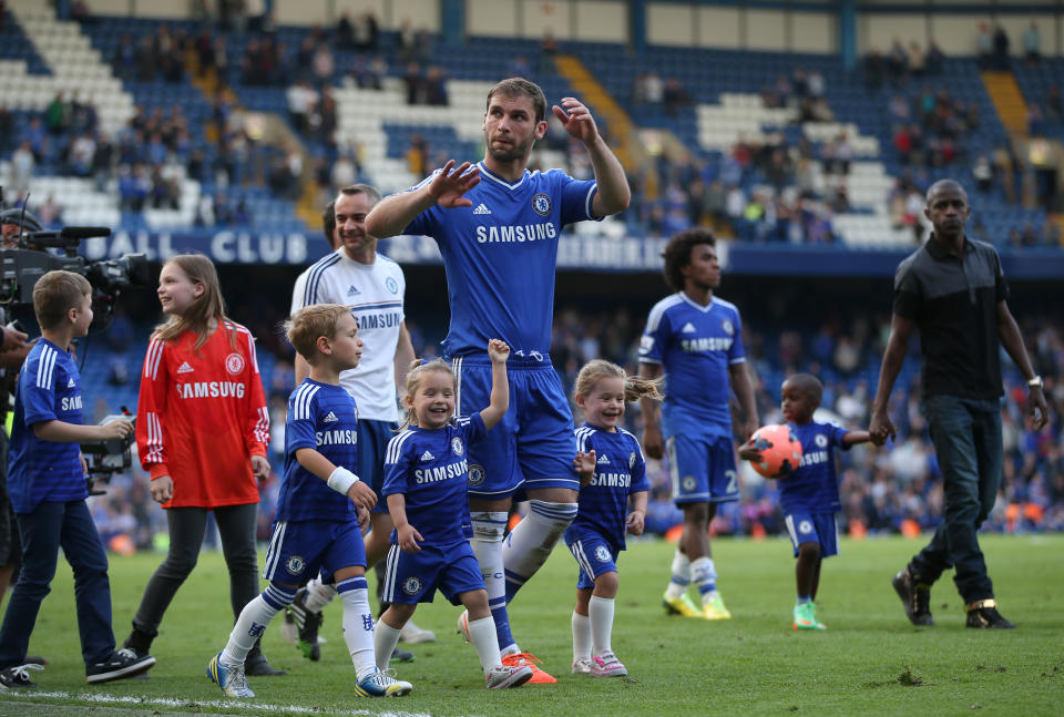 Chelsea's Branislav Ivanovic walks with his children on the pitch following the English Premier League soccer match between Chelsea and Norwich City at Stamford Bridge stadium in London Sunday, May 4, 2014. The players traditionally walk round the pitch with their family after the last home game of the season. (AP Photo/Alastair Grant)