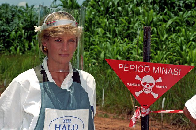 <p>John Stillwell - PA Images/PA Images via Getty</p> Princess Diana walks through an active landmine in Angola in 1997.