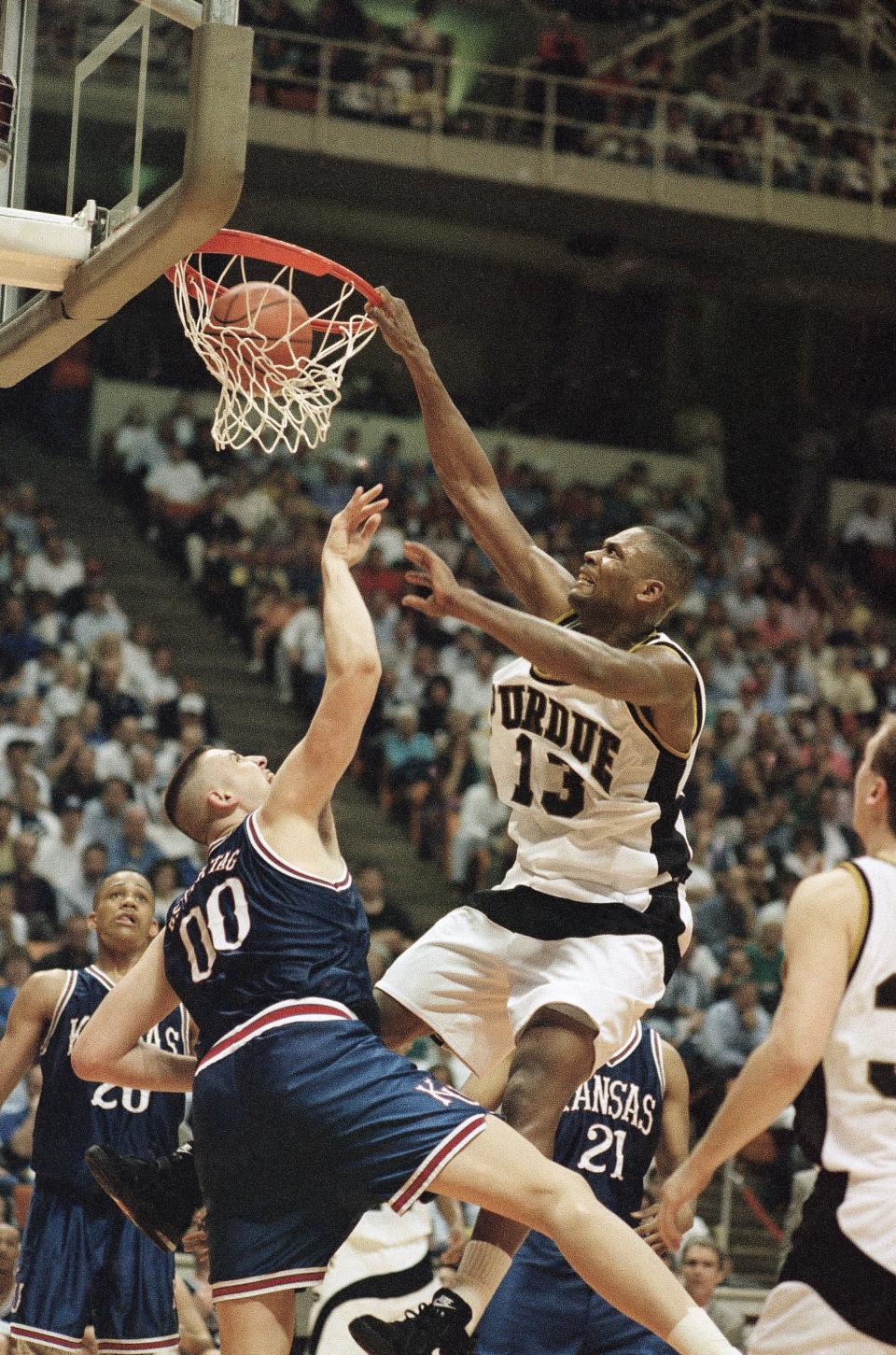 Purdue's Glenn Robinson (13) dunks over Kansas Greg Ostertag (00) in the first half of the NCAA Southeast Regional semi-final game in Knoxville, Tennessee Thursday, March 24, 1994. Purdue defeated Kansas 83-78. (AP Photo/Mark Humphrey)