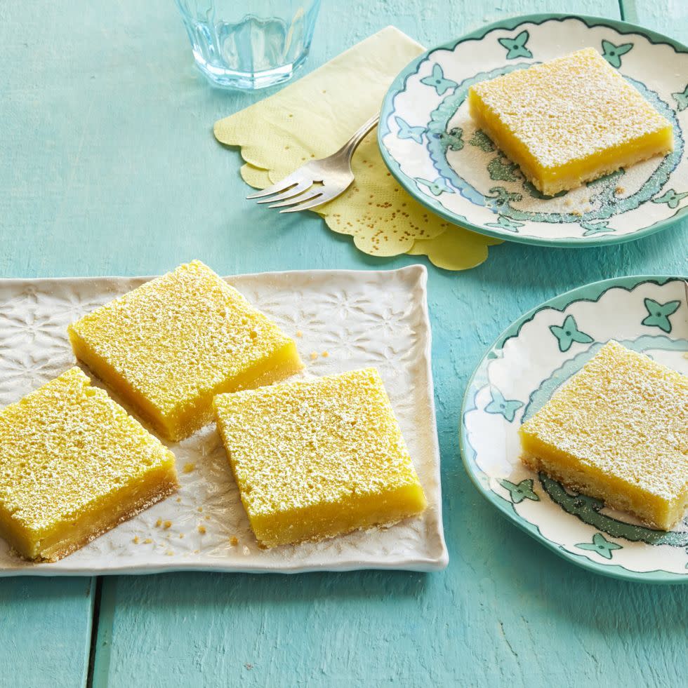 lemon bars on white tray and plate blue background