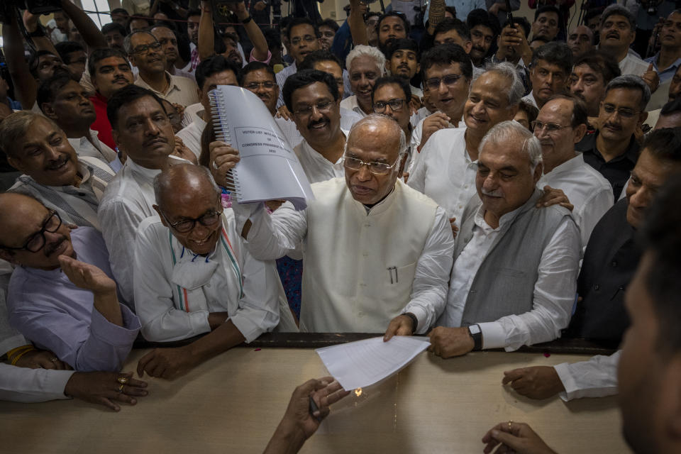 Senior Congress party leader Mallikarjun Kharge, center, shows his documents as he files his nomination papers for Congress party president at the party's headquarter in New Delhi, India, Friday, Sept. 30, 2022. India’s main opposition Congress party, long led by the politically powerful Nehru-Gandhi family, is set to choose a non-family member as its next president after a gap of more than two decades. (AP Photo/Altaf Qadri)