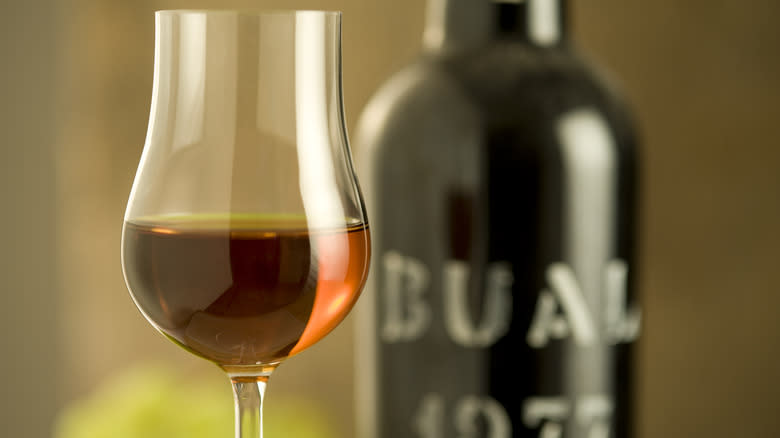 Glass of port wine in front of black bottle