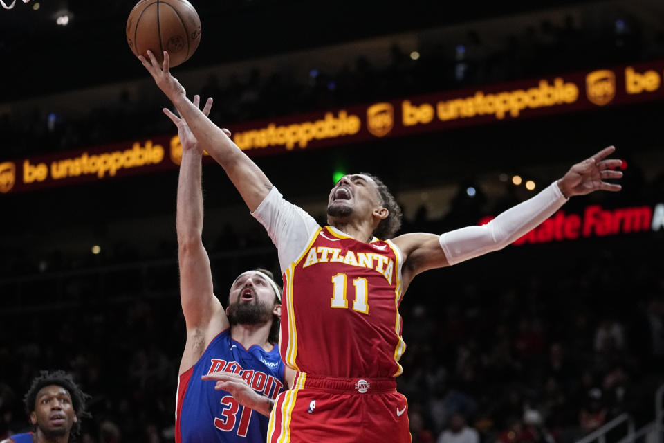 Atlanta Hawks guard Trae Young (11) goers up for a shot as Detroit Pistons forward Joe Harris (31) defends during the second half of an NBA basketball game Monday, Dec. 18, 2023, in Atlanta. (AP Photo/John Bazemore)y