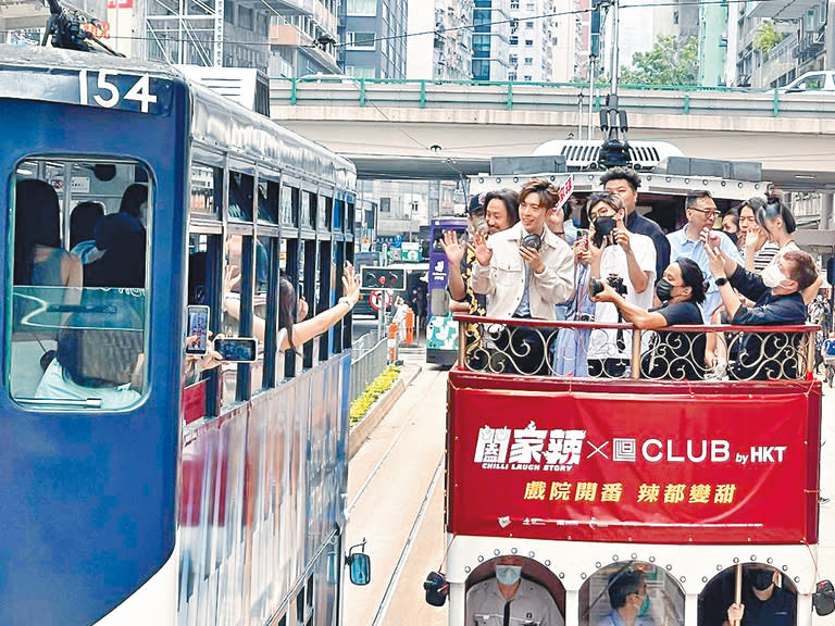 ■Other tram passengers extend their hands to greet the crowd.