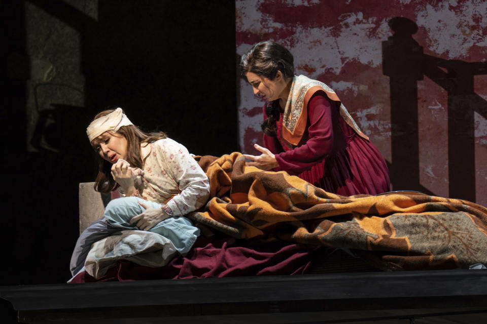 Karin Mushegain, right, who portrays Mariam, tends to Maureen McKay, who portrays Laila, during in a dress rehearsal for the opera "A Thousand Splendid Suns," in Seattle, on Wednesday, Feb. 22, 2023. Kabul-born author Khaled Hosseini, the book’s author who lives in California, had hoped the story would become a relic of the past, maybe a "cautionary tale.” But instead, he said, “what’s going on with women today is a cruel deja vu.” (AP Photo/Stephen Brashear)