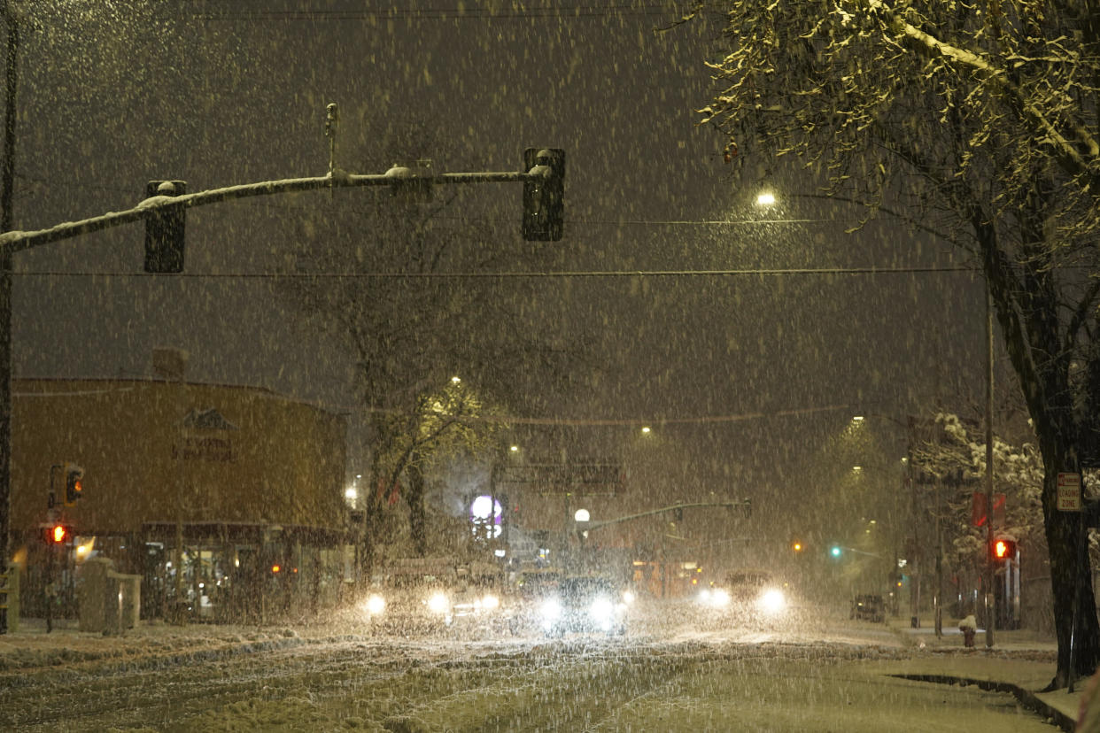 In this photo provided by Hung T. Vu, snow falls on North Market Street in Redding, Calif., early Friday, Feb. 24, 2023. Heavy rain and snow are pounding California and other parts of the West in the latest winter storm to hit the United States. (Hung T. Vu via AP)