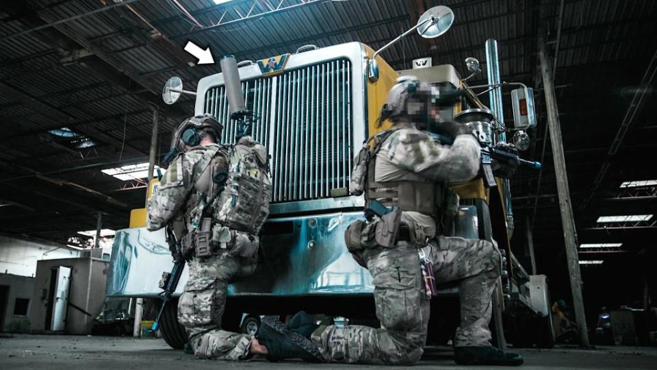 US Marine Raiders, one with a backpack version of the Joint Threat Warning System (JTWS) signals intelligence system, seen during a mock raid on a warehouse. <em>USMC</em>