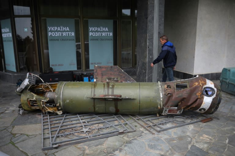 Un visiteur passe près des restes d'un missile utilisé durant la guerre entre l'Ukraine et la Russie, à l'entrée du musée de la Seconde Guerre mondiale à Kiev, le 8 mai 2022 (AFP/Aleksey Filippov)