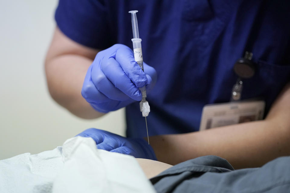 Ray Hoffman, who is immune-compromised, is given a shot of the two-shot dose of AstraZeneca's Evusheld — the first set of antibodies grown in a lab to prevent COVID-19, Thursday, Jan. 20, 2022, by Jose Lazaro, a medical assistant at a University of Washington Medicine clinic in Seattle. The two-shot dose is supposed to give patients like Hoffman, who can't make his own virus-fighters due to taking strong immune-suppressing drugs after liver and kidney transplants, some protection against COVID-19 for six months. (AP Photo/Ted S. Warren)