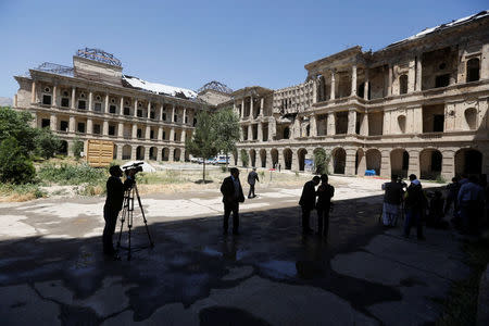 Cameramen film before the inauguration of the reconstruction project to restore the ruins of historic Darul Aman palace, in Kabul, Afghanistan May 30, 2016. REUTERS/Omar Sobhani