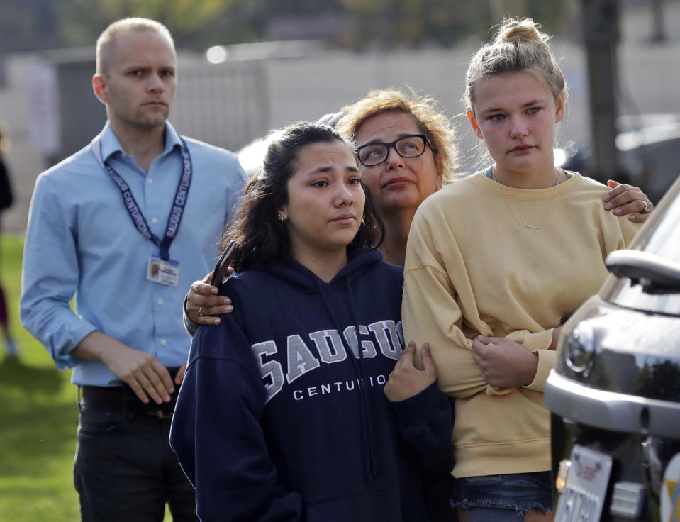 People wait outside of Saugus High School after reports of a shooting on Thursday, Nov. 14, 2019, in Santa Clarita, Calif. Los Angeles County Sheriff Alex Villanueva tweeted that the suspect was in custody and was being treated at a hospital. He said the suspect was a student but gave no further information.(AP Photo/Marcio Jose Sanchez)