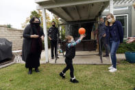 The Schmidt family, from, left, Heather Schmidt, her husband Nicholas Philbrook, son Andrew, 4, father Raymond and daughter Ava interact in their backyard, Wednesday, Nov. 18, 2020, in Camarillo, Calif. Philbrook and his wife have been trying to convince court officials that he should be excused from jury duty because her father, a cancer survivor with diabetes, lives with them. But court officials told him that is not a valid reason and he must appear in court in early December. (AP Photo/Marcio Jose Sanchez)