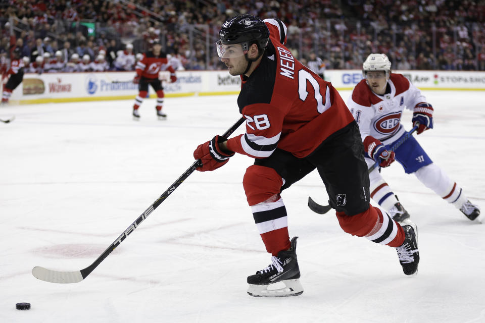 New Jersey Devils right wing Timo Meier (28) controls the puck past Montreal Canadiens right wing Brendan Gallagher during the second period of an NHL hockey game Wednesday, Jan. 17, 2024, in Newark, N.J. (AP Photo/Adam Hunger)