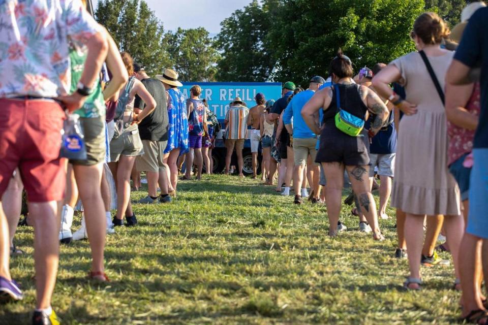 People wait in line to get water at a water refill station at the Railbird Festival at Keeneland in Lexington, Ky., on Saturday, Aug. 28, 2021.