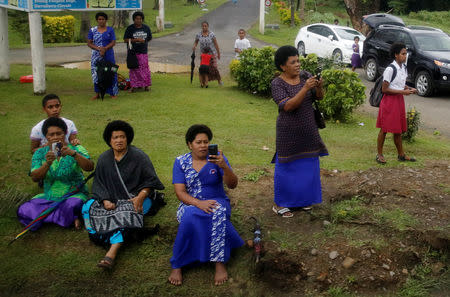 A crowd of people wait along a street as Britain's Prince Harry and Meghan, Duchess of Sussex, arrive in Suva, Fiji, October 23, 2018. REUTERS/Phil Noble