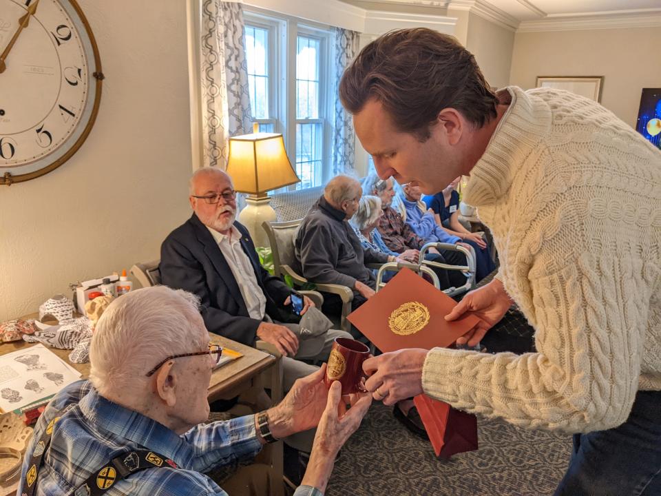 Portsmouth Mayor Deaglan McEachern presents gifts to John B. Robinson at his 101st birthday party at the Inn at Edgewood.