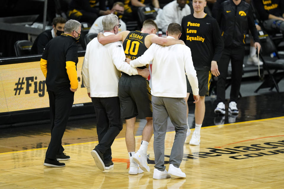 Iowa guard Joe Wieskamp (10) is helped off the court after getting injured during the first half of an NCAA college basketball game against Wisconsin, Sunday, March 7, 2021, in Iowa City, Iowa. (AP Photo/Charlie Neibergall)