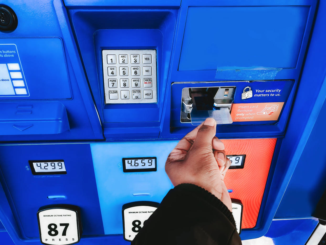 Woman Purchases Gas at Pump