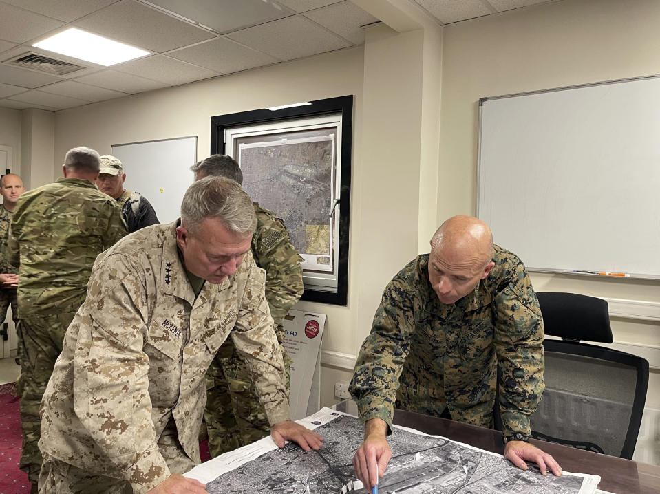 U.S. Marine Corps Gen. Frank McKenzie, center left, the commander of U.S. Central Command, and U.S. Marine Brig. Gen. Farrell J. Sullivan, the commander of the Naval Amphibious Task Force 51/5th Marine Expeditionary Brigade, review an aerial photo, at Hamid Karzai International Airport, Kabul, Afghanistan, Tuesday, Aug. 17, 2021. (Capt. William Urban/U.S. Navy via AP)