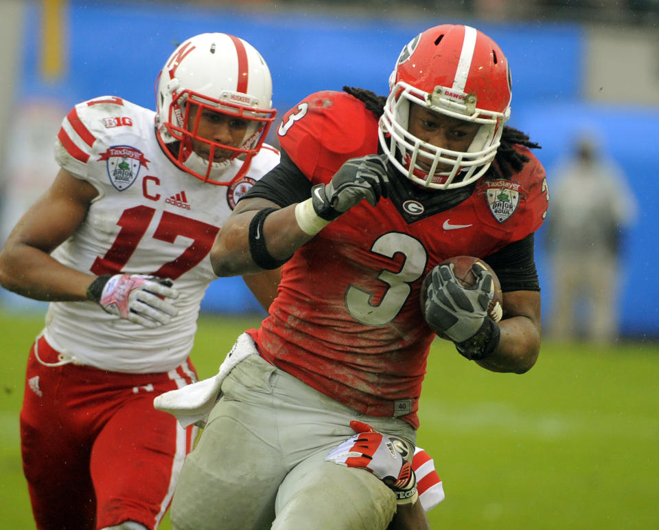 Georgia running back Todd Gurley (3) runs for yardage while being chased by Nebraska cornerback Ciante Evans (17) in the second half of the Gator Bowl NCAA college football game, Wednesday, Jan. 1, 2014, in Jacksonville, Fla. Nebraska beat Georgia 24-19. (AP Photo/Stephen B. Morton)